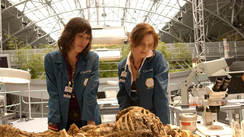 Michaela Conlin as Angela and Emily Deschanel as Dr. Temperance Brennan examining a skeleton on Bones