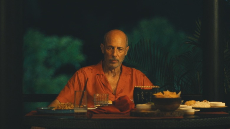 Gary's Aka Greg Gris does not look at the table where he sits alone in the white lotus