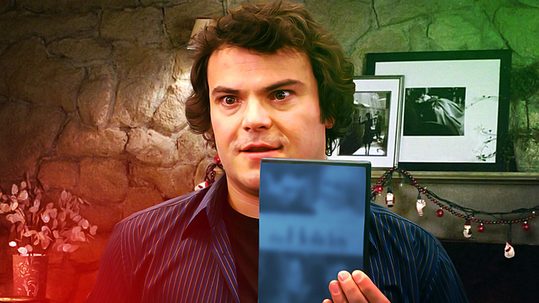 Jack Black's Miles Dumont holds up a DVD of The Holiday with the cover blurred