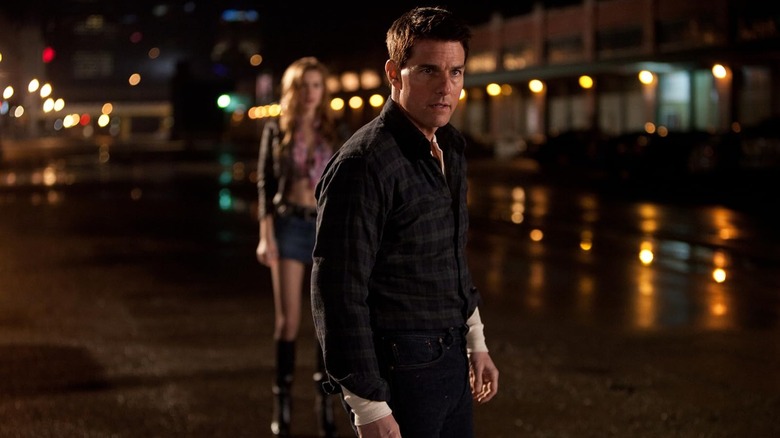 Tom Cruise flexes as Jack Reacher as Alexia Fast as Sandy watches in Jack Reacher