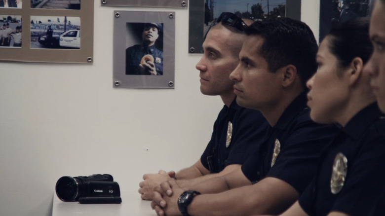 Jake Gyllenhaal's Brian Taylor and Michael Peña's Mike Zavala sit side by side during a morning meeting in End of Watch