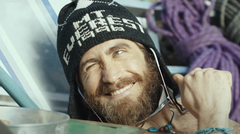 Jake Gyllenhaal's Scott Fischer smiles while sitting down in Everest