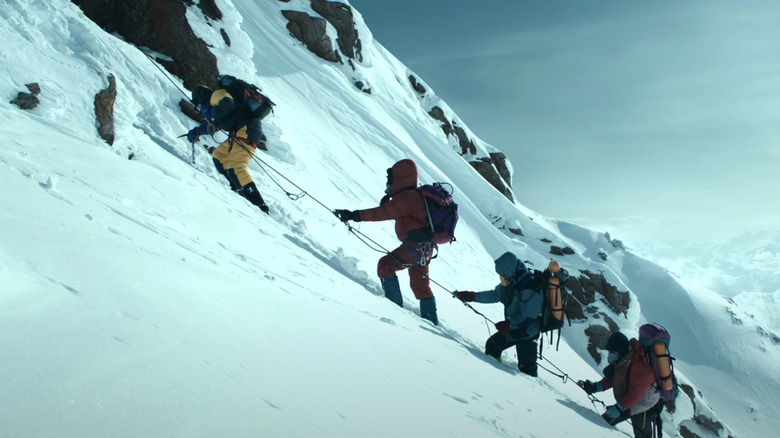 A row of climbers traverse a steep incline in Everest