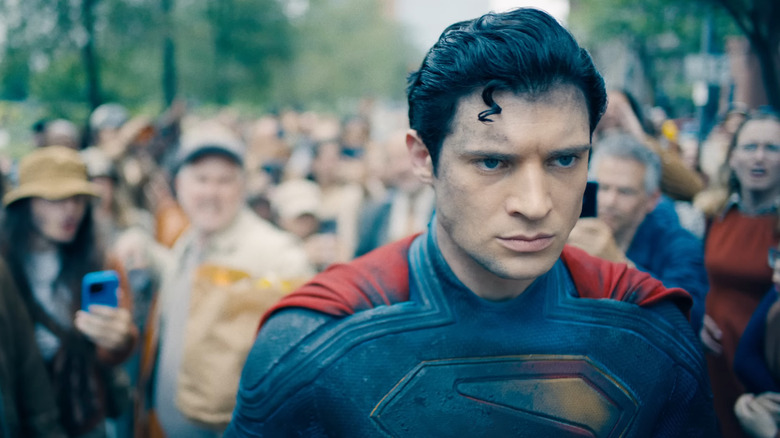 David Corenswet's Superman walking away from a mob of people in Superman (2025)