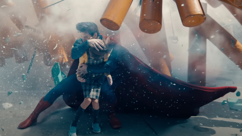 David Corenswet como Superman protegiendo a un niño de la explosión de escombros en Superman (2025)