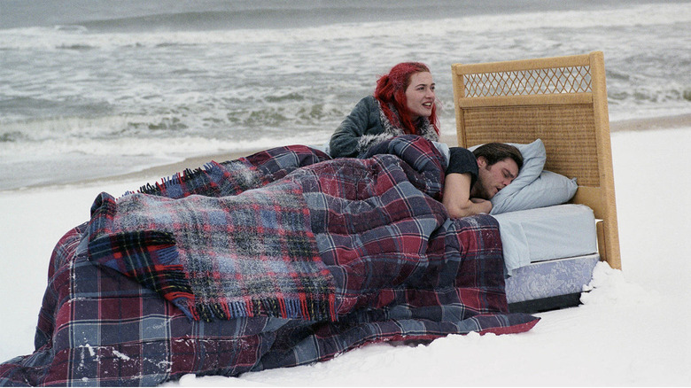 Kate Winslet's Clementine and Jim Carrey's Joel in bed on a beach in Eternal Sunshine of the Spotless Mind