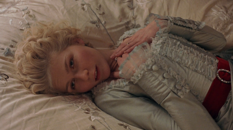 Kirsten Dunst as Marie Antoinette lying on her bed in Marie Antoinette