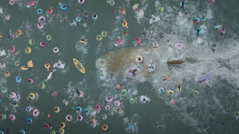 The Megaladon swims beneath a crowd of swimmers in The Meg