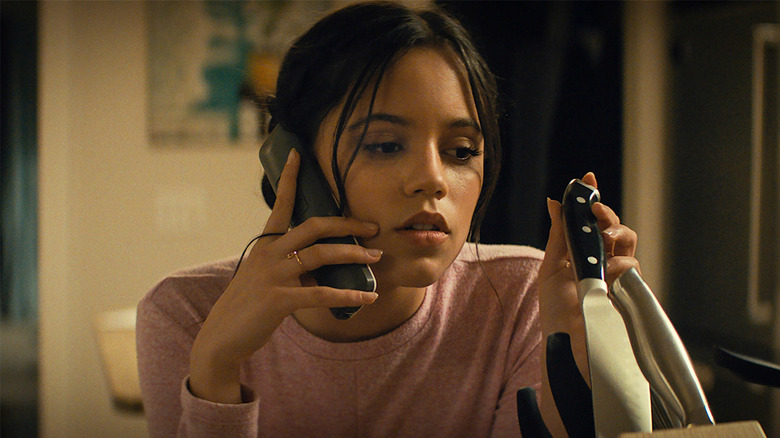 Tara Carpenter holds a knife while on the phone in Scream (2022)