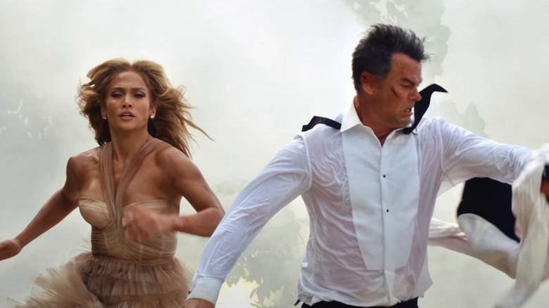 Jennifer Lopez's Darcy Rivera and Josh Duhamel's Tom Fowler run side by side on a beach in wedding attire in Shotgun Wedding