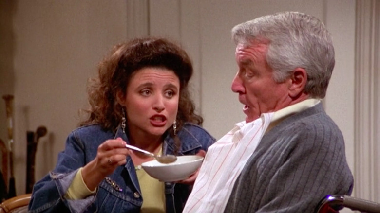 Julia Louis-Dreyfus como Elaine intenta alimentar a Edward Penn como Owen en Seinfeld