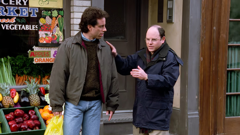 Jerryi Seinfeld as Jerry and Jason Alexander as Georgeore stands in front of Seinfeld's food store