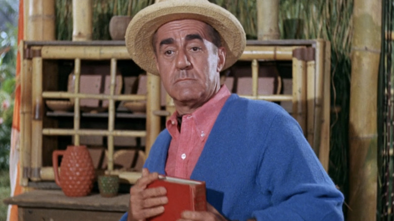 Jim Backus' Thurston Howell III looks surprised as he holds a book in Gilligan's Island