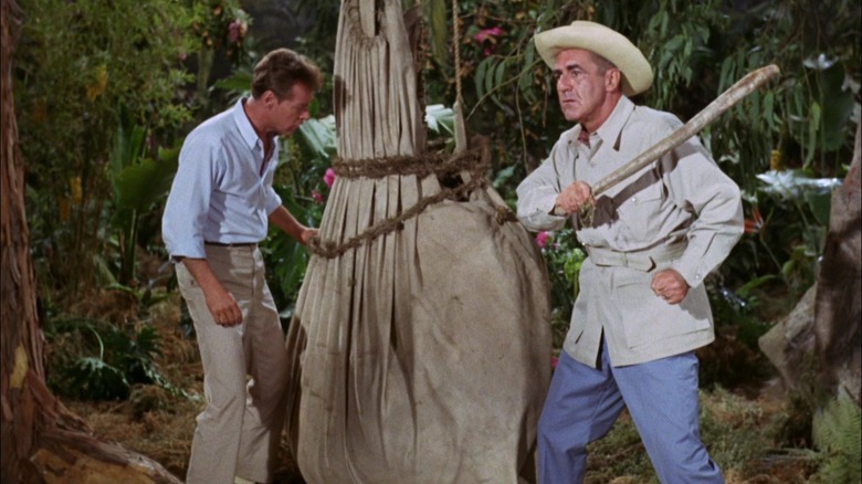 El Profesor y el Sr. Howl golpearon algo en una bolsa que colgaba de un árbol en la Isla de Gilligan.