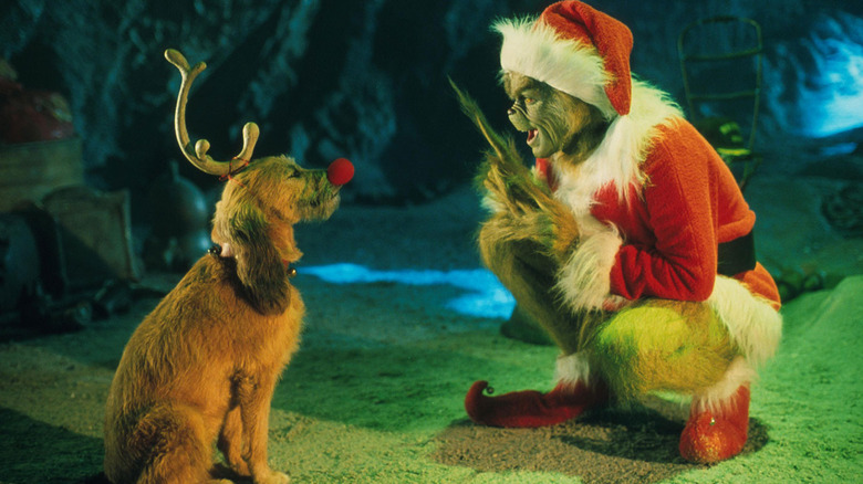 The Grinch crouches next to his dog Max in How the Grinch Stole Christmas