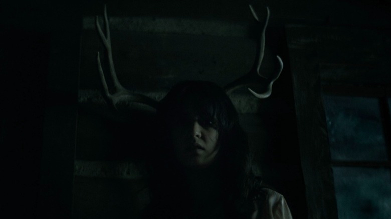 Yellowjackets season 1 Lottie in shadow with antlers behind her