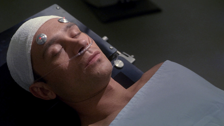 Trip Tucker from Star Trek: Enterprise laying on a medical gurney, gauze and electrodes on his head.