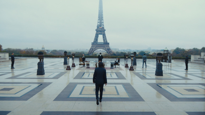 John Wick Chapter 4 john approaches table in front of eiffel tower