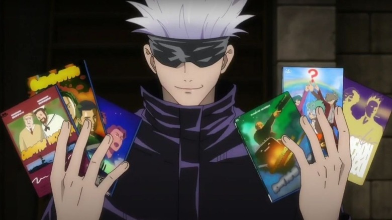 Gojo holds a bunch of DVD cases in his hands in Jujutsu Kaisen