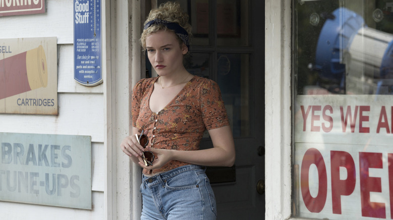 Julia Garner holding sunglasses