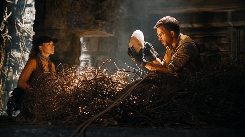 Jonathan Bailey as Henry Loomis and Scarlett Johansson as Zora Bennett inspecting a dinosaur egg in Jurassic World Rebirth