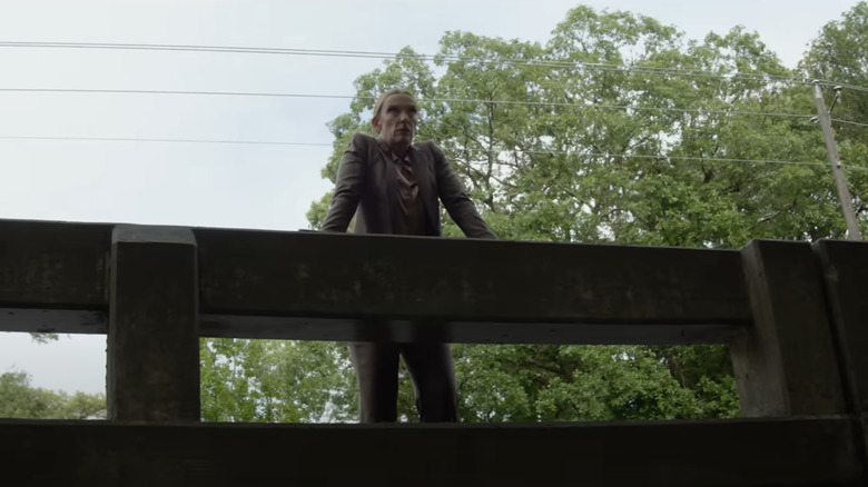 Toni Collette's Faith Killebrew  stands looking over the edge of a bridge in Juror #2