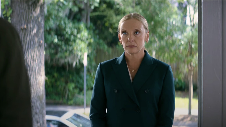 Toni Collette's Faith Killebrew stands on the porch of a home looking in through the open front door in Juror #2