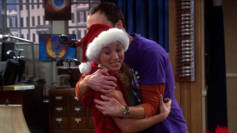 Sheldon hugging Penny wearing a Santa hat on The Big Bang Theory