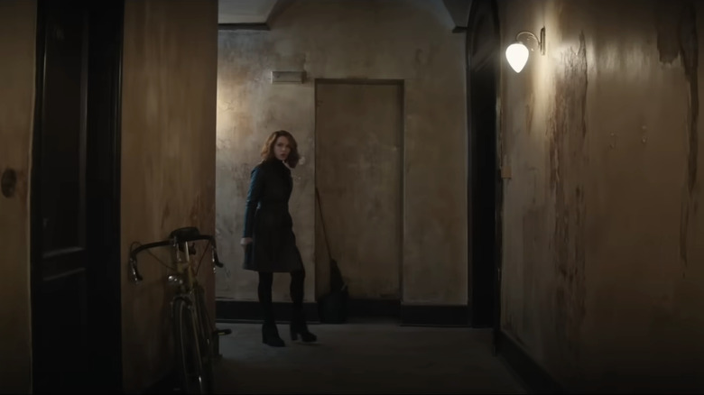 Avery Graves is seen at the end of an apartment block hallway in Canary Black