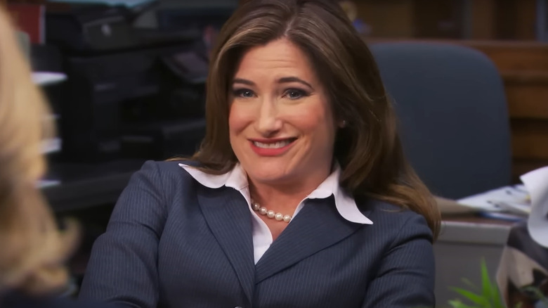 Kathryn Hahn as Jennifer Barkley smiling in an office chair on Parks and Recreation