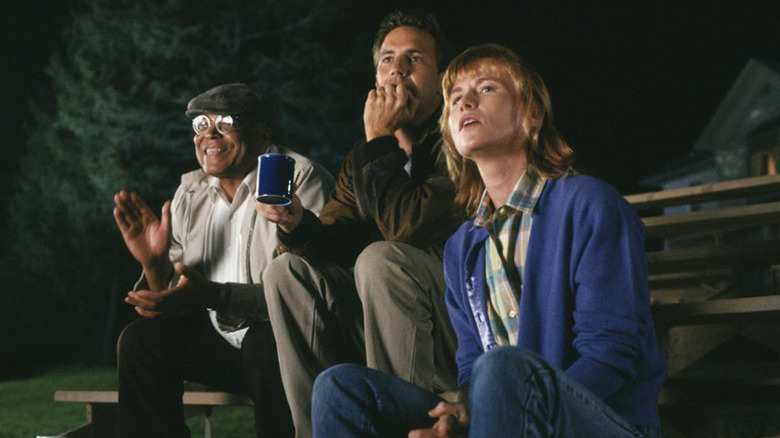 Ray and Annie Kinsella seated with Terence Mann watching baseball in Field of Dreams