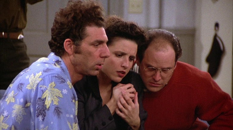 Kramer, Elaine, and George looking concerned at something on Seinfeld