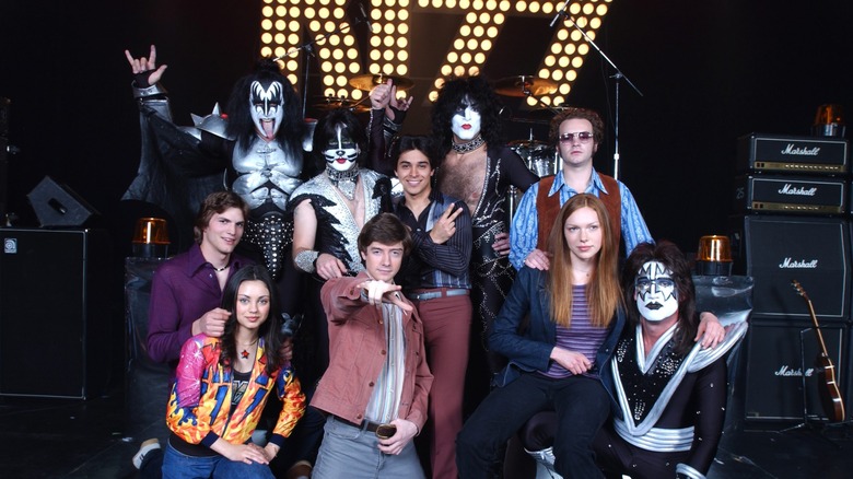 The main cast of That 70's Show poses with rock band KISS.