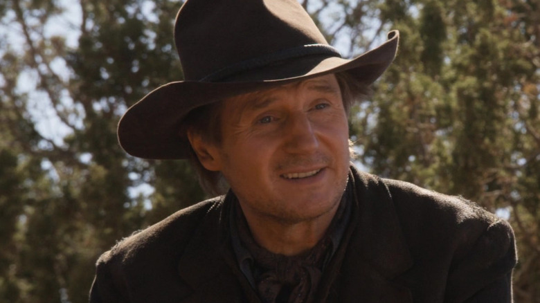 Liam Neeson smiling as Clinch Leatherwood in A Million Ways to Die in the West