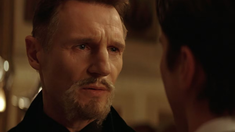 Liam Neeson como Al Ghul de Ra olha seriamente em Batman Begins