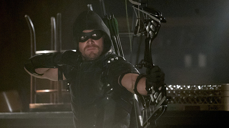 Oliver Queen preparing to shoot an arrow in Arrow