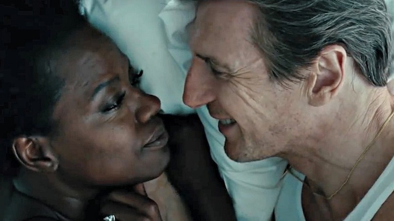 Liam Neeson como Harry Rawlings abraços com Viola Davis como Veronica Rawlings em viúvas