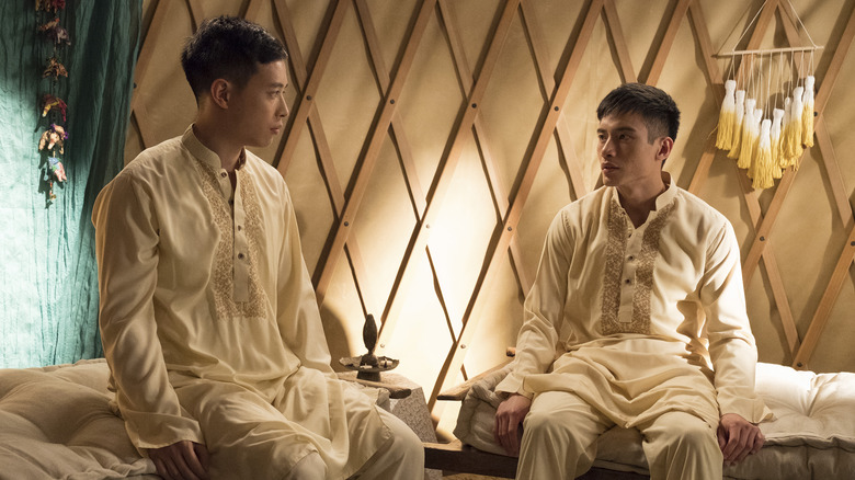 Manny Jacinto as Jason Mendoza with a Buddhist monk in The Good Place