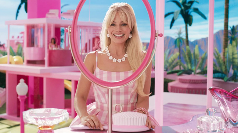 Margot Robbie looking at a vanity mirror in Barbie