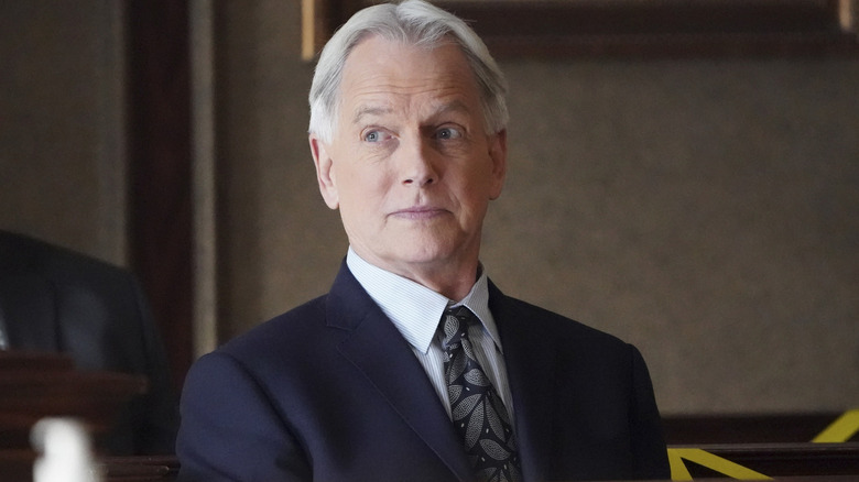 Gibbs olha para a direita com um sorriso sutil no NCIS