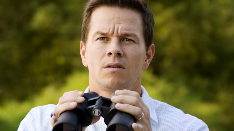 Mark Wahlberg as Elliot Moore holding binoculars in The Happening