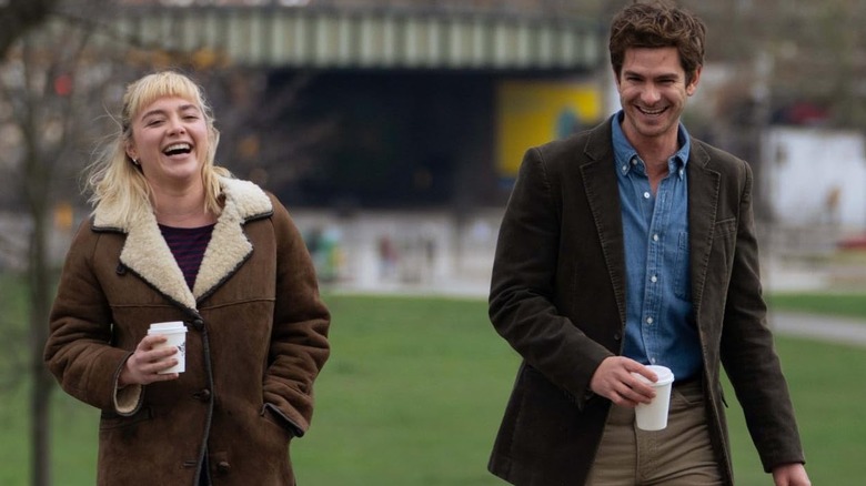 Almut and Tobias walking and laughing with coffee in We Live in Time