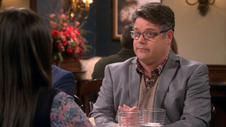 Dr. Pemberton sitting at a restaurant table in The Big Bang Theory.