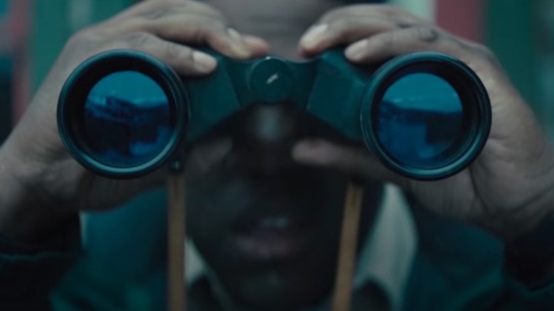 Sam Richardson looks through binoculars as Finn Wheeler in Werewolves Within