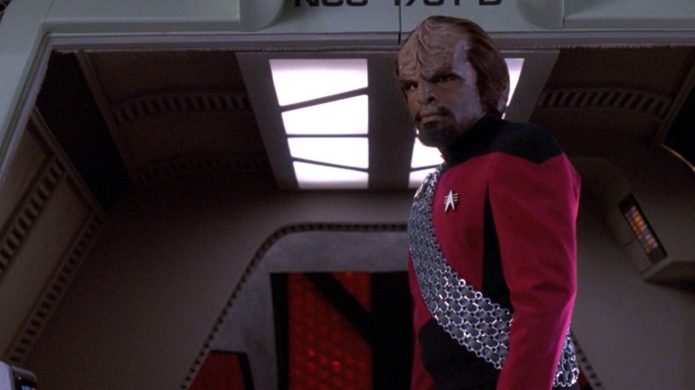 Michael Dorn como Worf, em um uniforme vermelho do Universo Parelle, prestes a embarcar em uma escravo em Star Trek: a próxima geração.