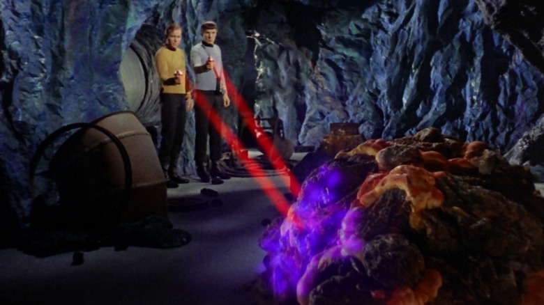 Kirk and Spock firing their phasers at a Horta in an episode of Star Trek.