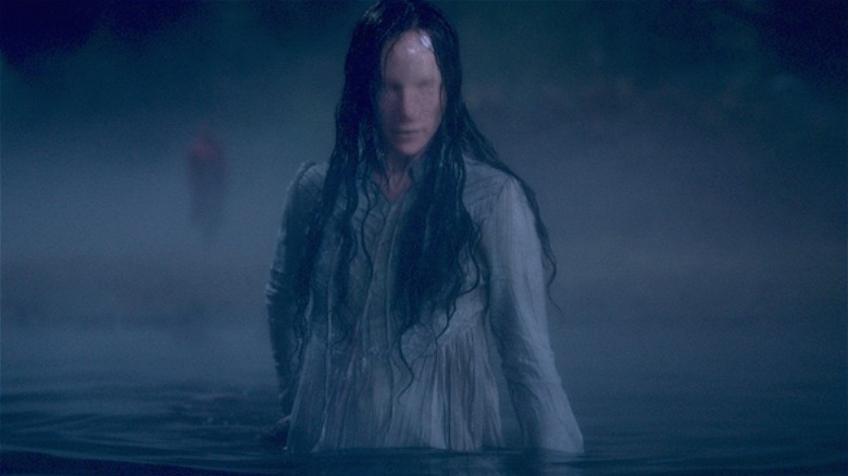 Faceless woman rises from lake