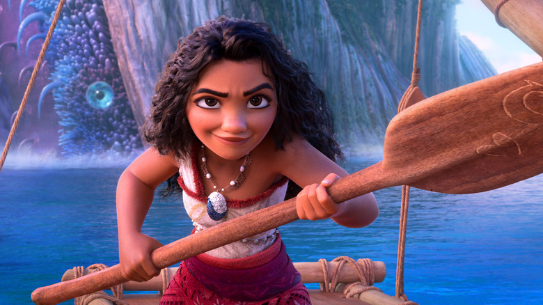 Moana wields her oar in defiance while a monster lurks behind her in Moana 2