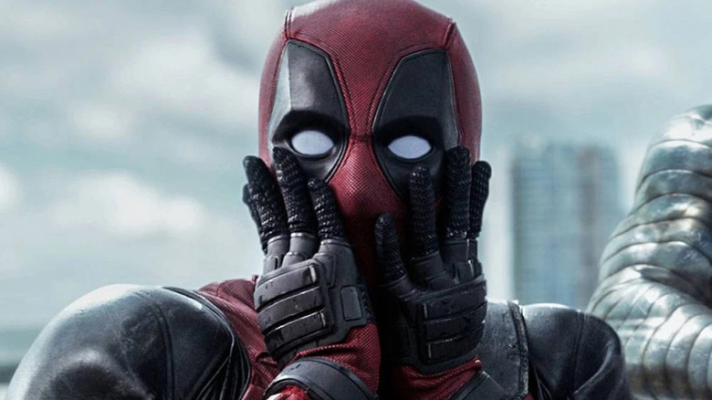 deadpool in full costume with both hands on his face in shock