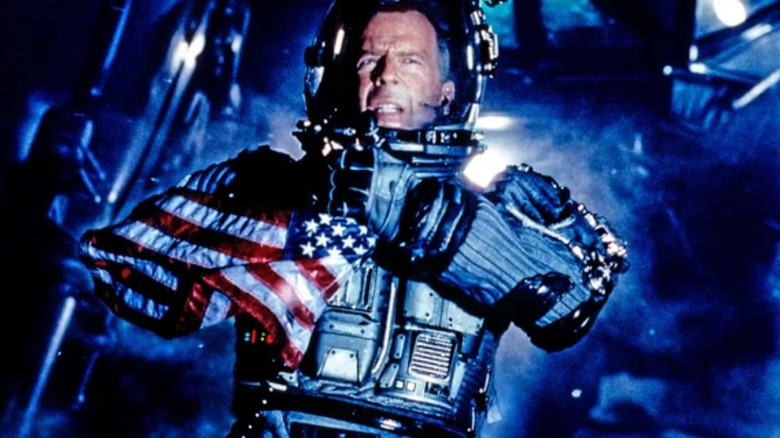 Harry Stamper wears a space suit and holds an American flag in Armageddon